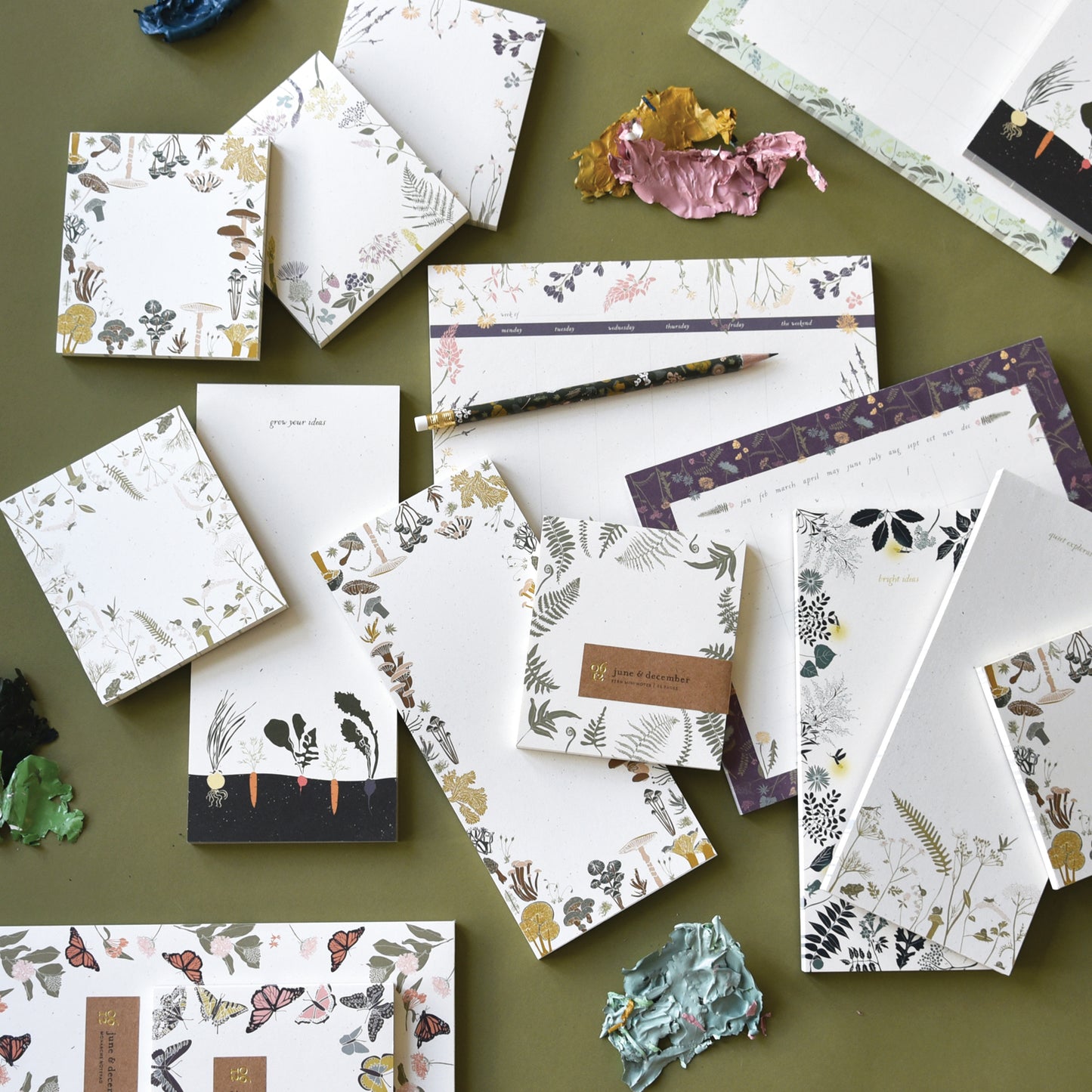 Eco-friendly Fern Mini Notepad displayed in the center around different notepad elements designed by katie forte of june & december