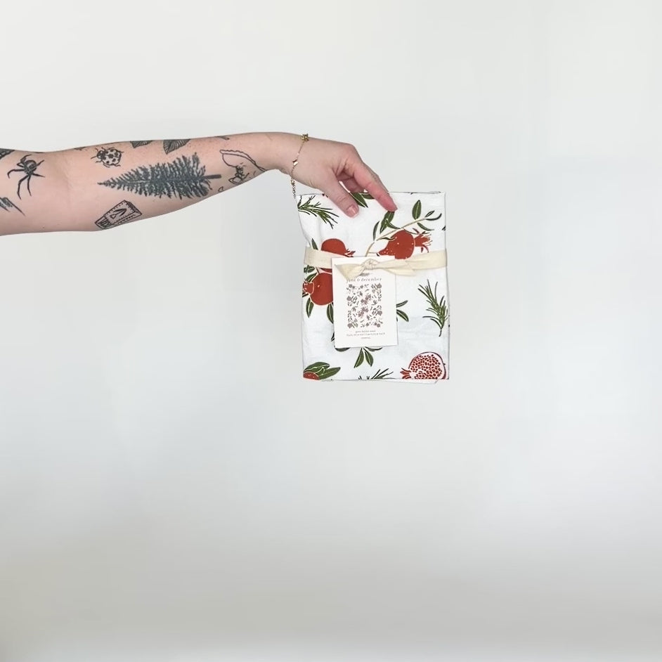 Load and play video in Gallery viewer, Video featuring our Poms tea towel design, accented with gold glitter, and printed on flour sack cotton. A perfect addition to your holiday decor. Designed by Katie Forte of June &amp;amp; December

