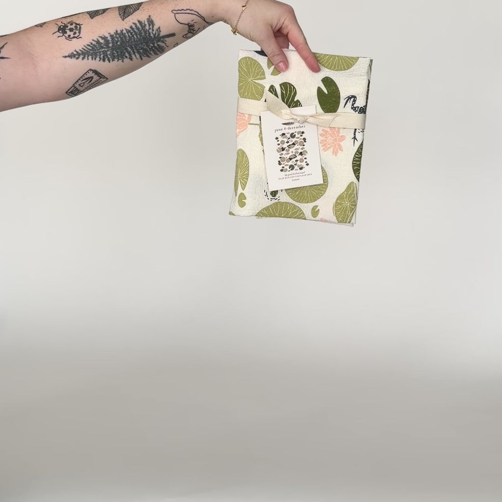 Load and play video in Gallery viewer, Video featuring our Lily Pond tea towel design. Screen printed on flour sack cotton, a perfect gift for the frog fiend. Designed by Katie Forte of June &amp;amp; December
